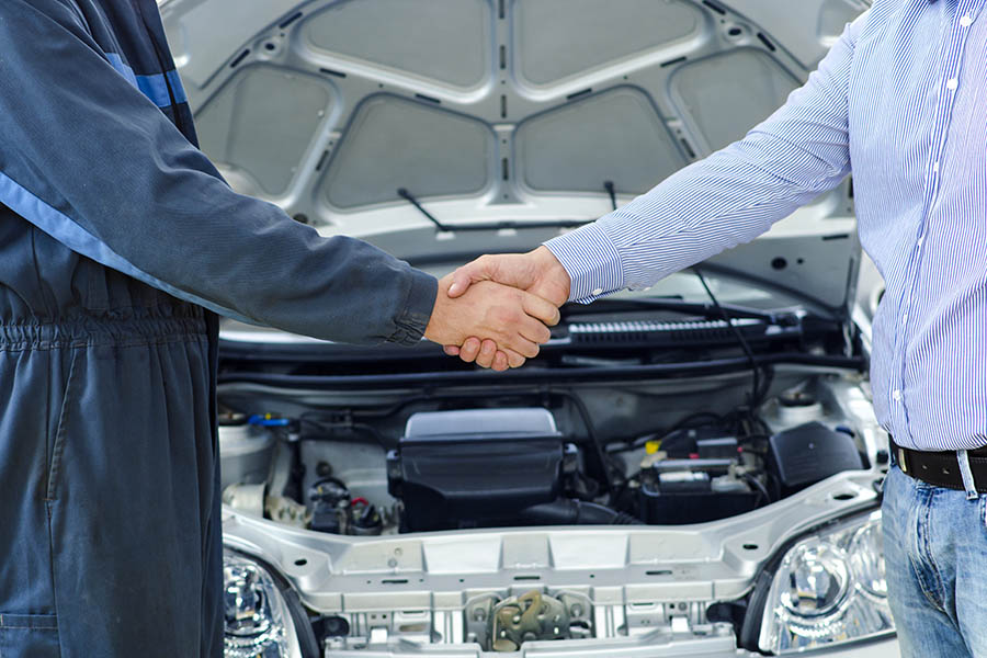 mechanic and auto repair customer shaking hands